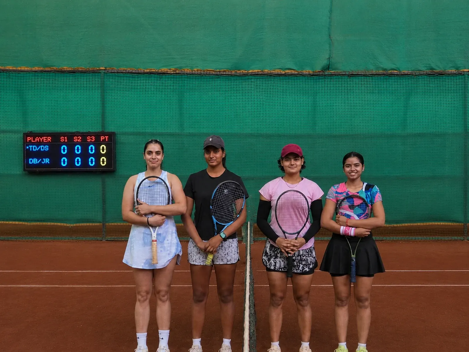 Four players on court at a club, the Tovio board lit behind them