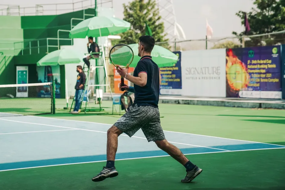 A local tournament in progress, umpire chair and umbrellas courtside