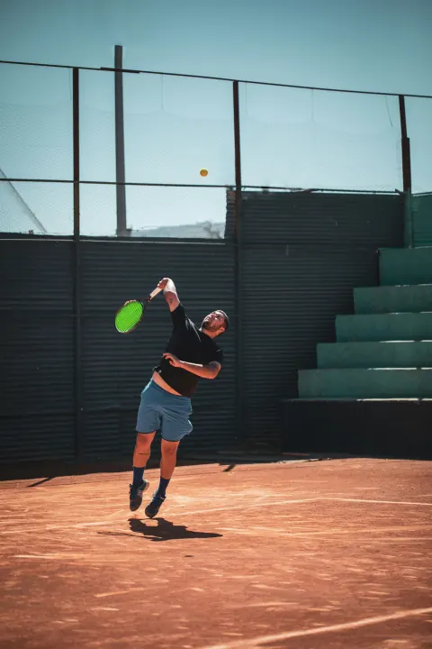 Tennis player serving on clay court