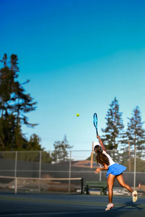 Tennis player serving outdoors