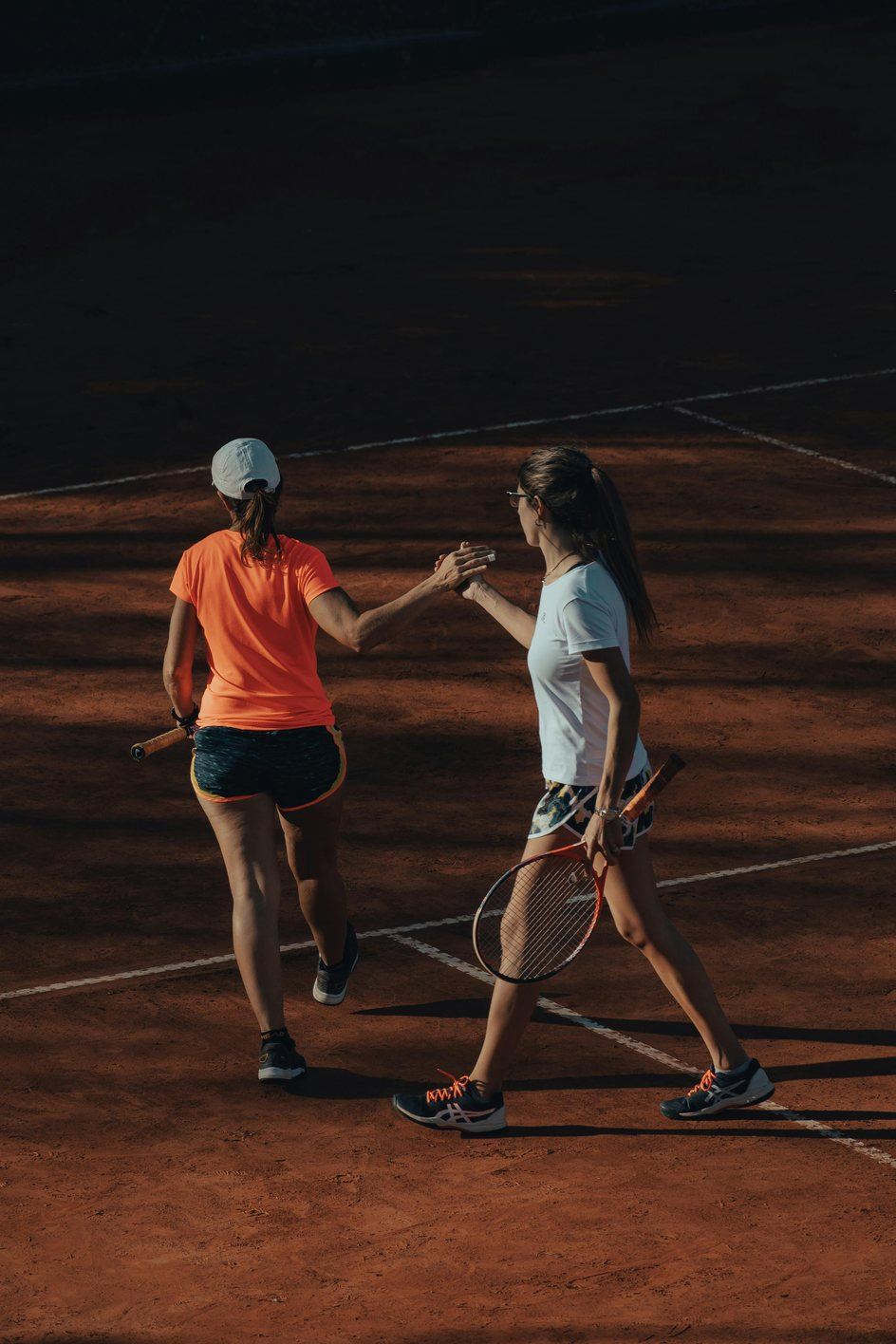 Two juniors meeting at the net after a point on clay